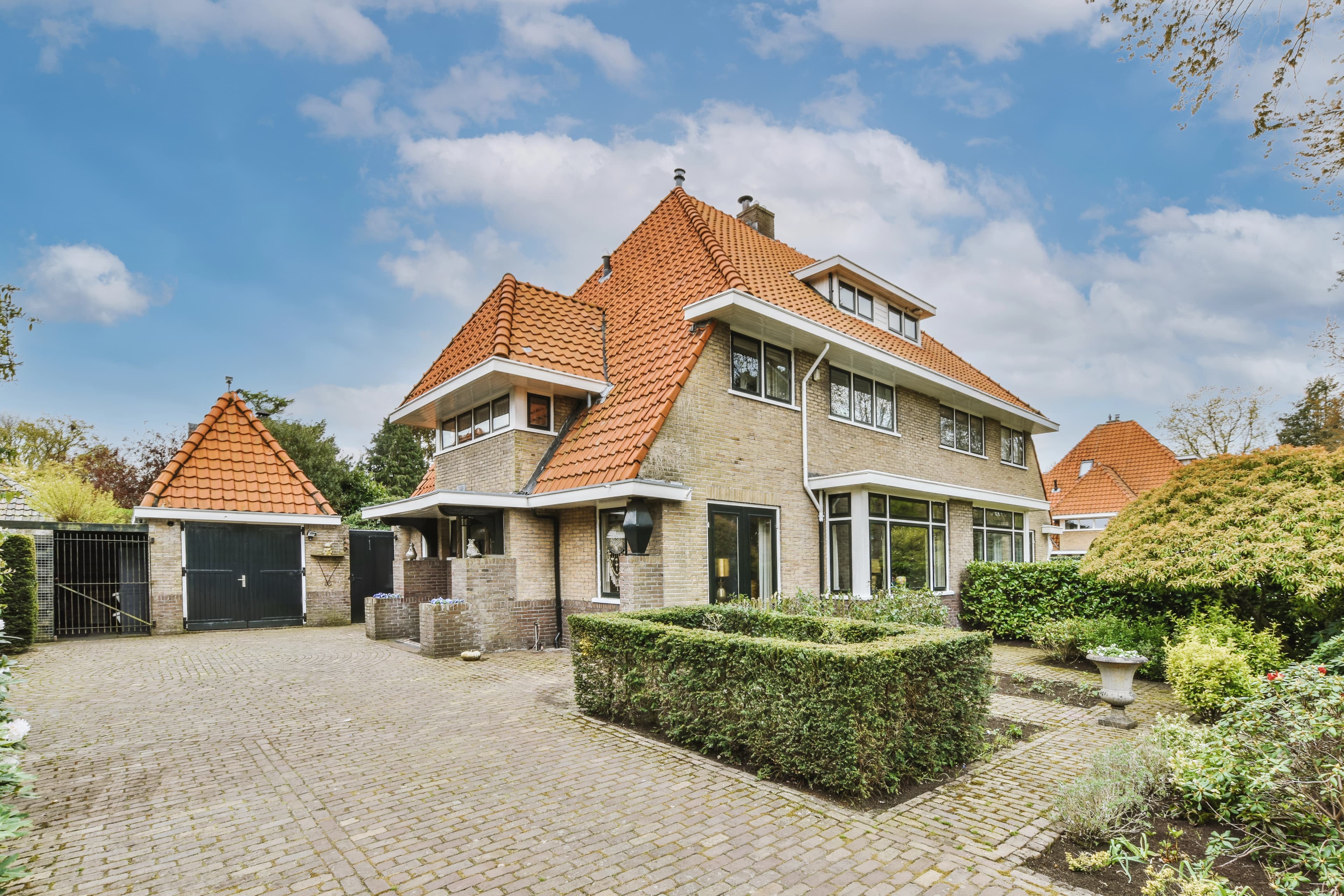 Een huis met daarond wat struiken